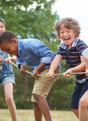 children playing tug of war, all smiling
