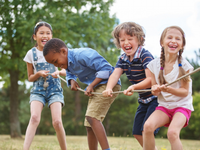 children playing tug of war, all smiling